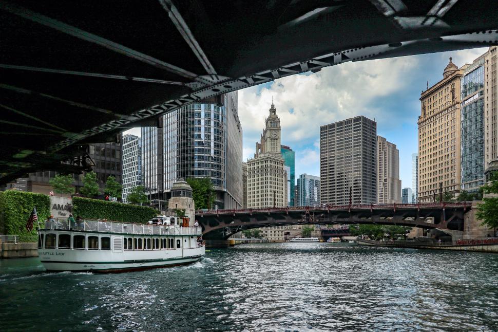 Free Image of Under the Bridge View of Chicago River with Passing Tour Boat 
