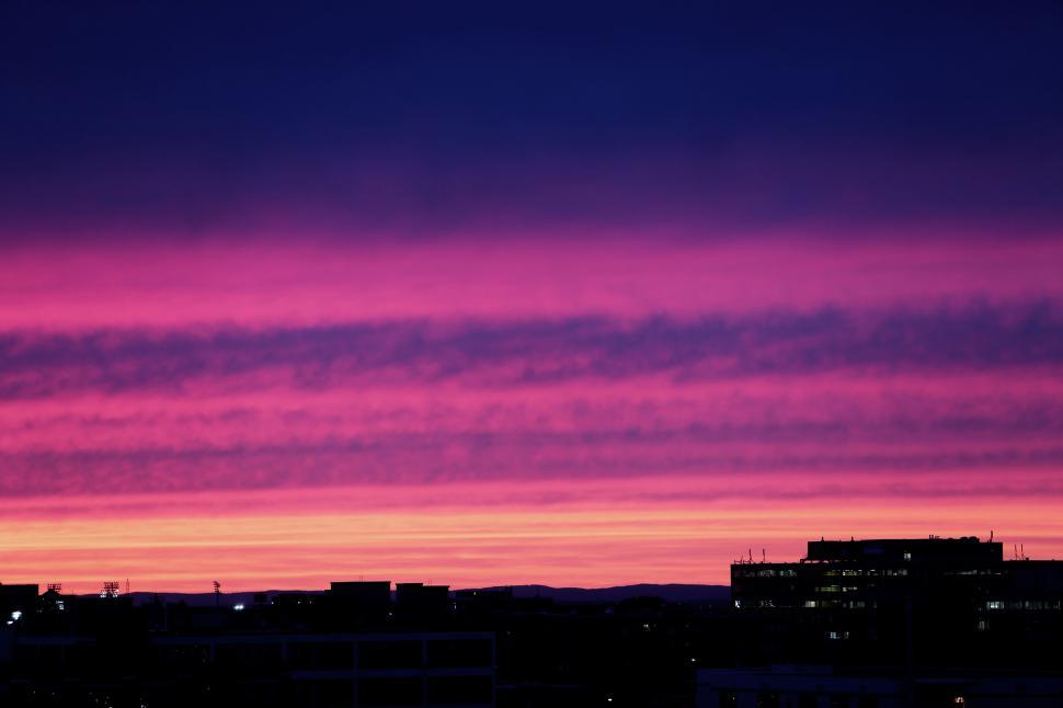 Free Image of Vivid purple and pink sunset over modern cityscape at twilight hour 