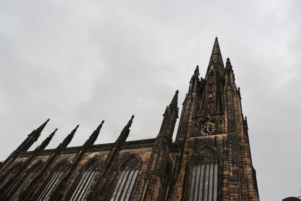 Free Image of Gothic-style cathedral with towering spires under a cloudy sky. 