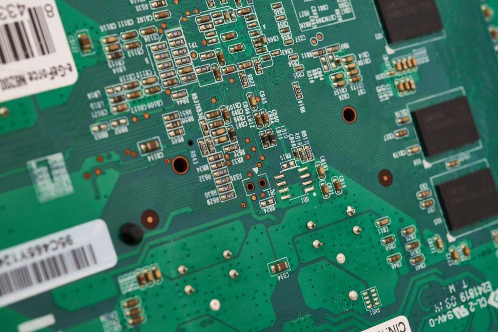 Free Image of Green circuit board with intricate pathways and technological elements 