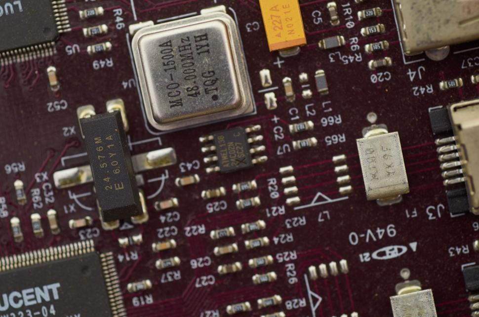 Free Image of Close-up of electronic microchips and components on maroon PCB 