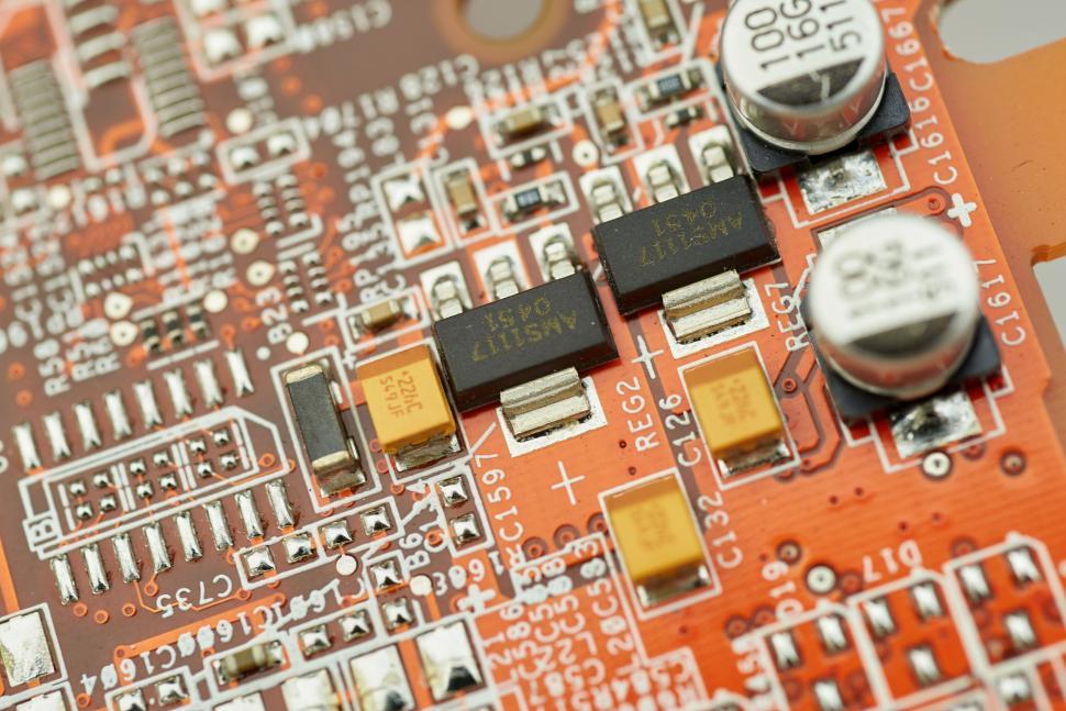 Free Image of Close-up view of a red circuit board with various electronic components 