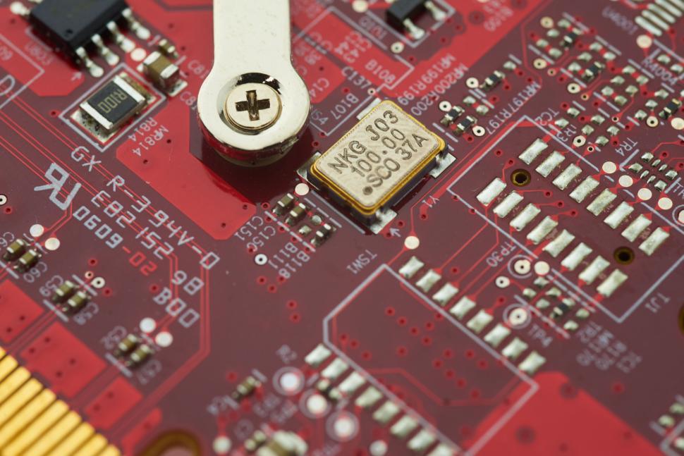 Free Image of Close-up of a red circuit board with integrated circuits and screws 