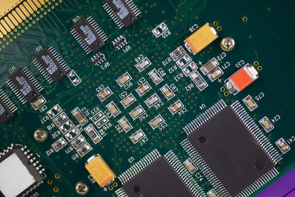 Free Image of Close-up of a green circuit board with numerous electronic components. 