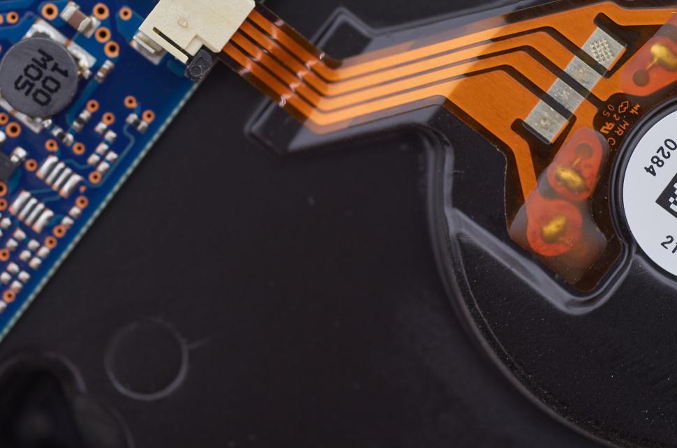 Free Image of Close-up image of electronic components and orange ribbon cables. 