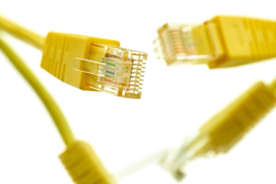 Free Image of Yellow ethernet cables with clear connectors on a white background. 