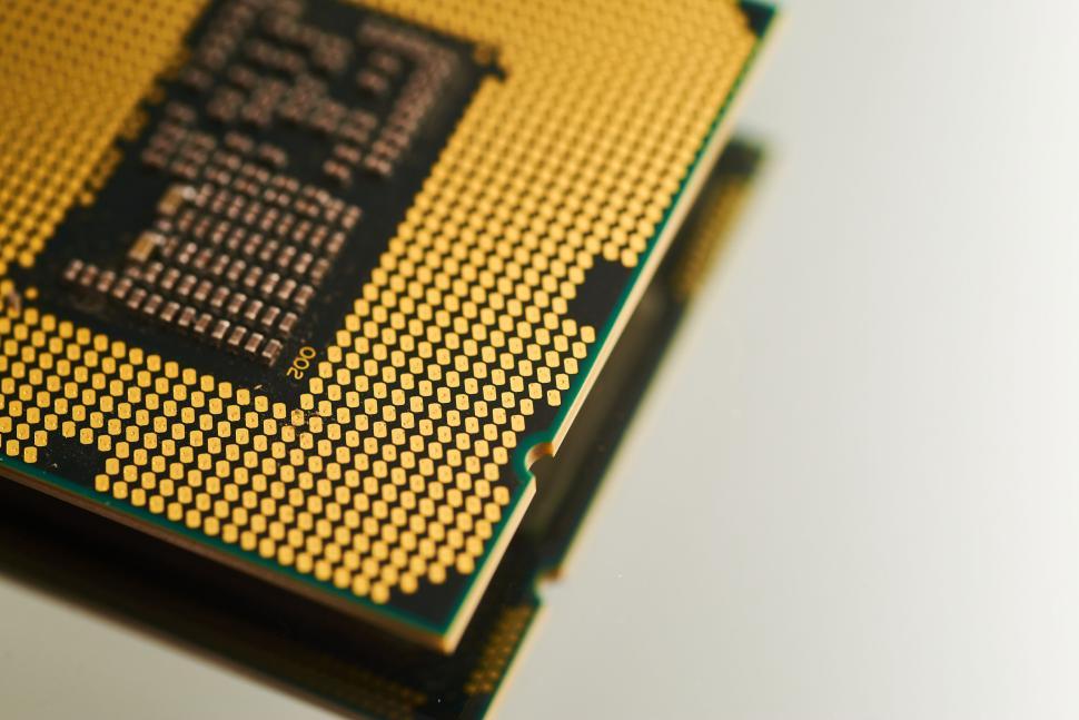 Free Image of Close-up of a CPU showing gold pins and intricate circuitry design 