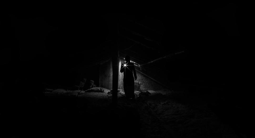 Free Image of Person exploring dark, eerie place with the help of flashlight. 