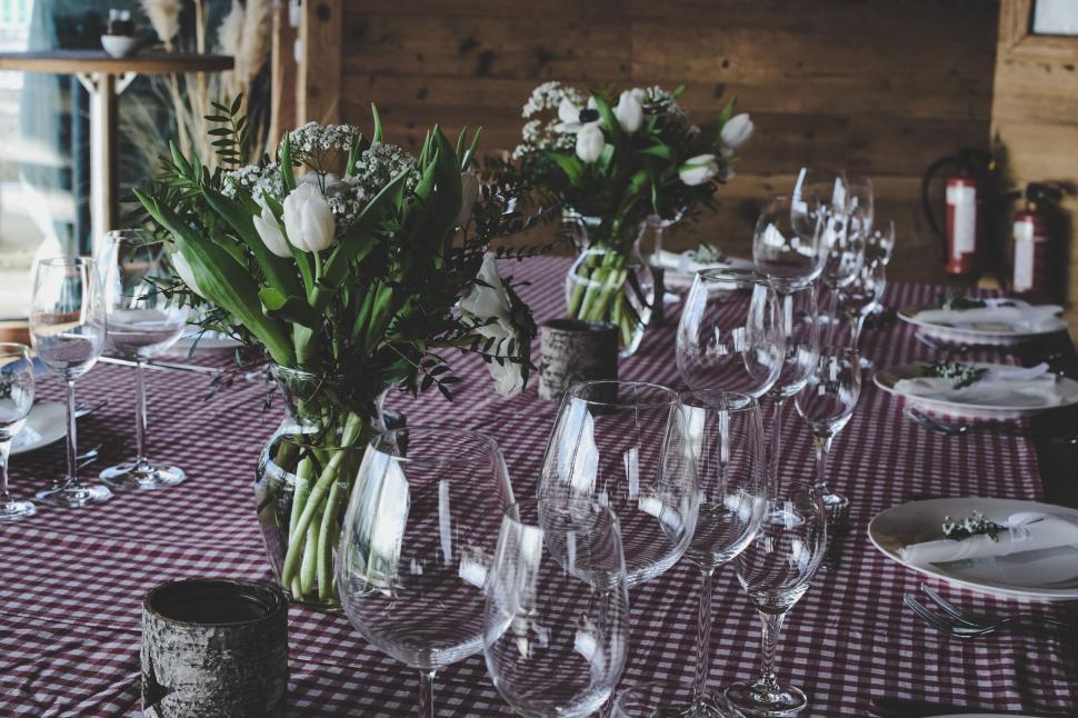 Free Image of Elegantly set dining table with flowers and glasses for guests dining. 