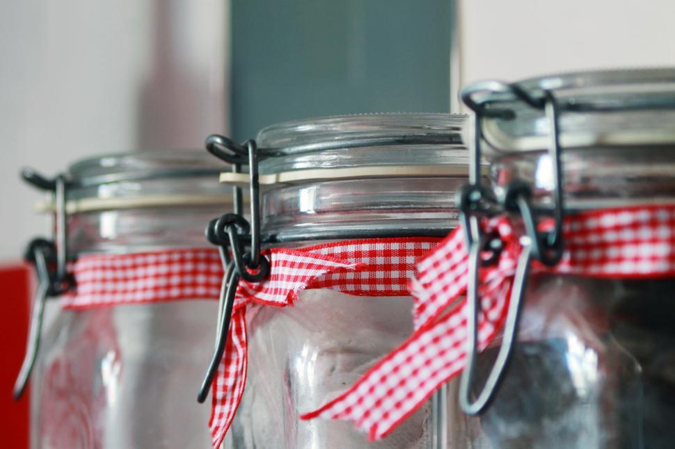 Free Image of Close-up view of three jars with red checkered fabric decorations 