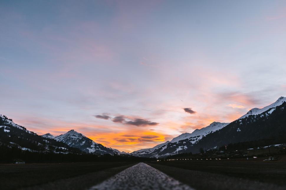 Free Image of Distant view of a snow-capped mountain with sunset sky background 