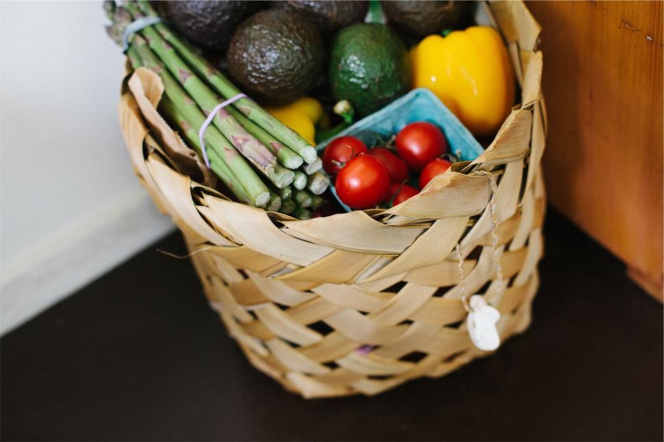 Free Image of Wicker basket filled with fresh vegetables including tomatoes and asparagus 