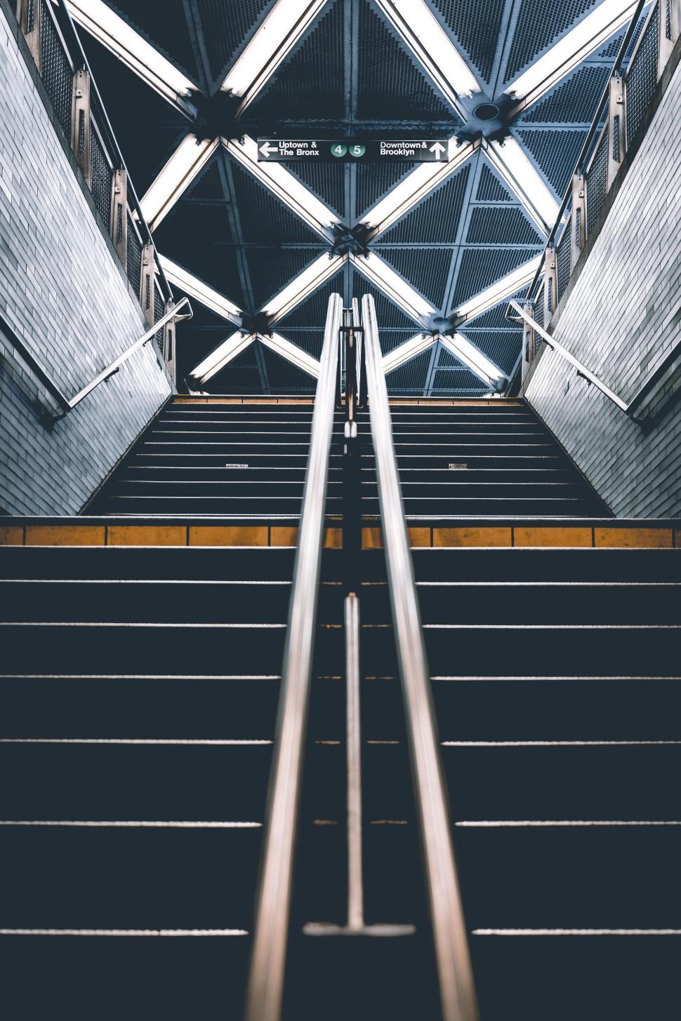 Free Image of Modern subway entrance with symmetrical stairs and geometric lights. 