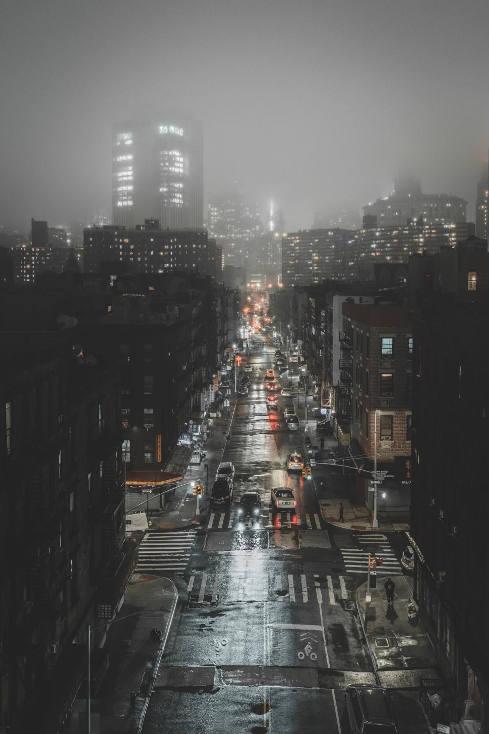 Free Image of Rainy night street with slick roads and shining city lights. 