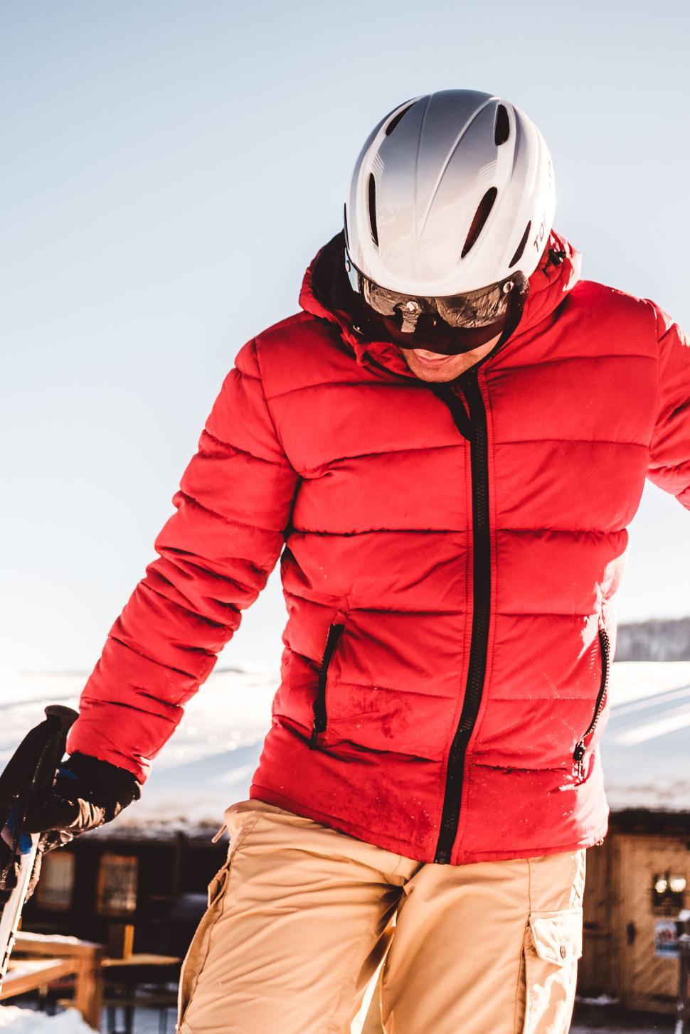 Free Image of Person in red jacket skiing with snowy mountains in background. 