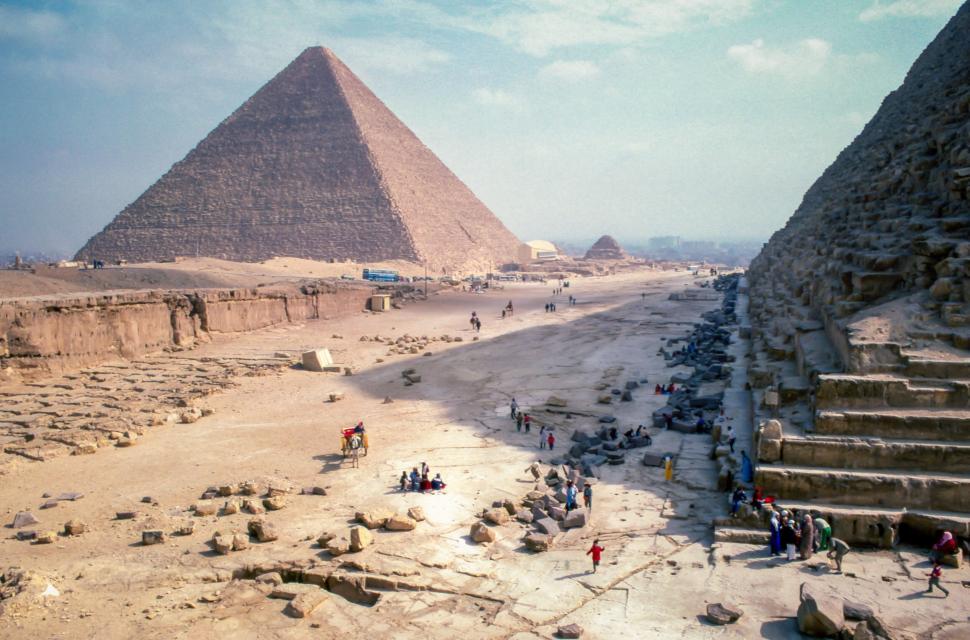 Free Image of Egyptian pyramids with tourists exploring the ancient site 