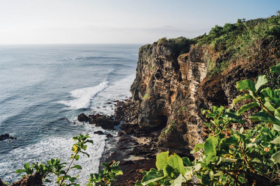 Free Image of Majestic cliff edge with ocean waves crashing below in daylight 
