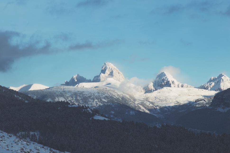 Free Image of Snow-covered mountain peaks under a clear blue sky in daylight 
