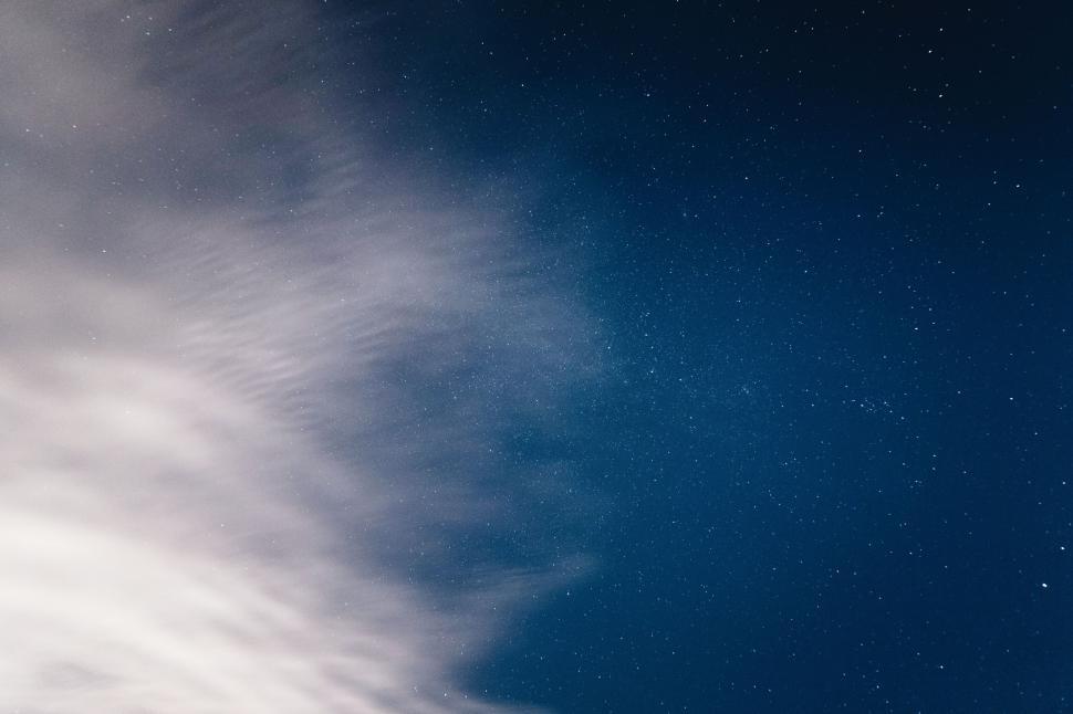 Free Image of Starry night sky blending with wispy clouds in breathtaking view 
