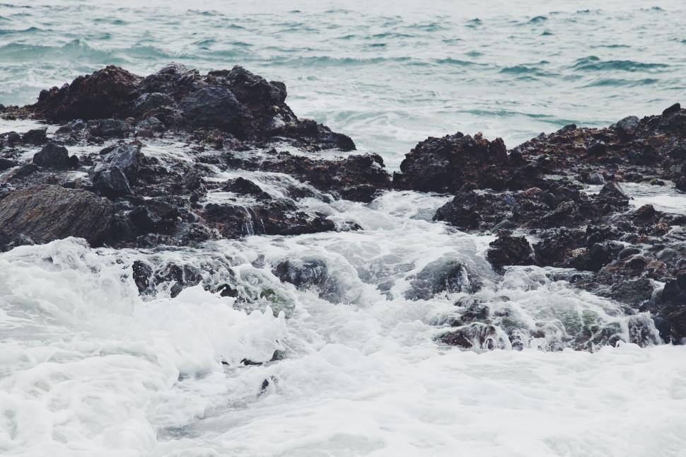 Free Image of Powerful waves crashing over rocky shoreline along an ocean coast 