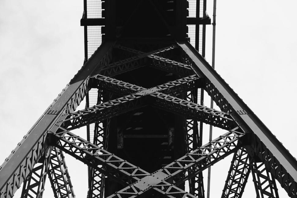 Free Image of View from bottom looking up at a large metal industrial bridge structure 