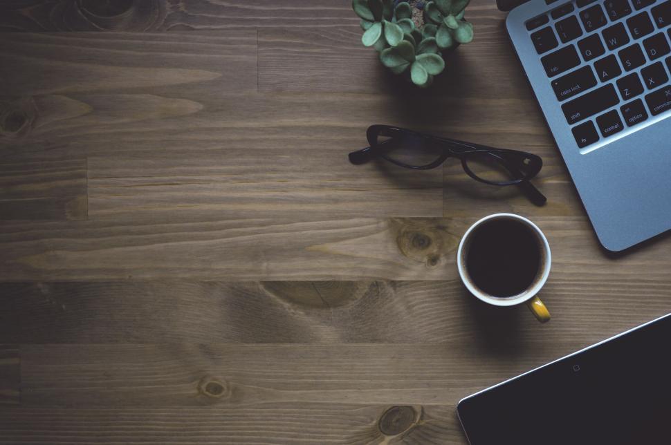 Free Image of Minimalistic workspace setup with laptop, glasses, and coffee cup. 
