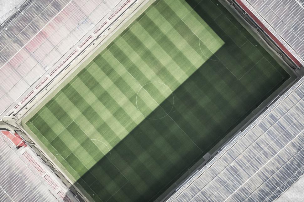 Free Image of Aerial view of green football field in a stadium with striped grass 