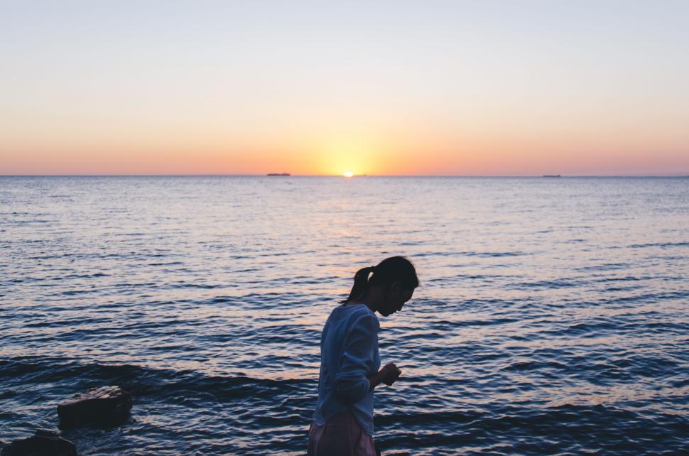 Free Image of Person enjoys a serene seaside view during sunset at the beach. 