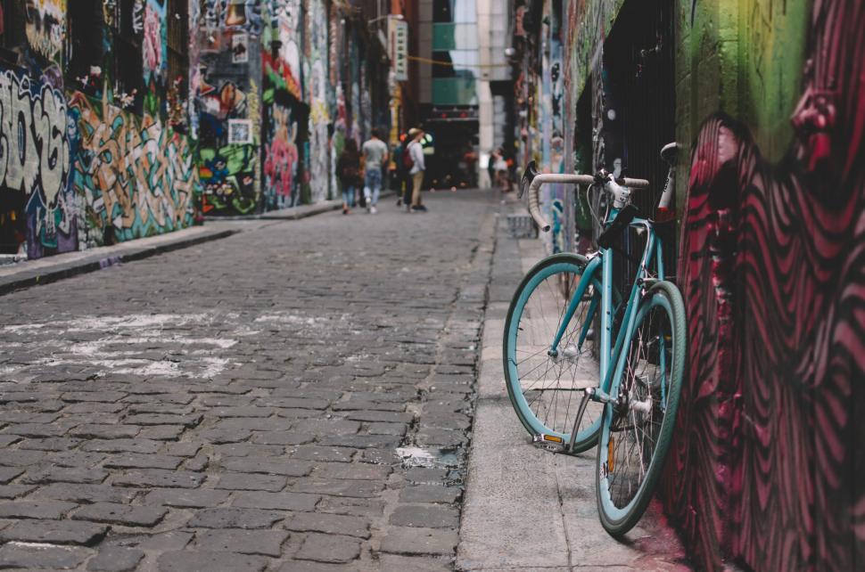 Free Image of Bicycle leaning against colorful graffiti wall in a street alley 
