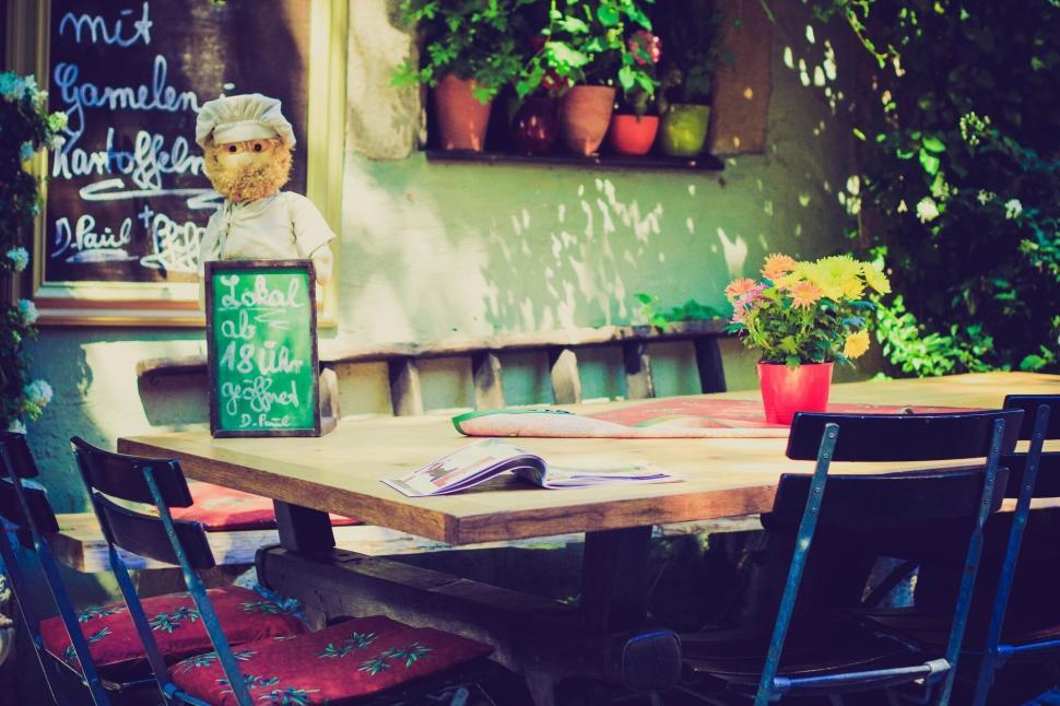Free Image of Charming outdoor caf? setting with table and decorations in shade. 