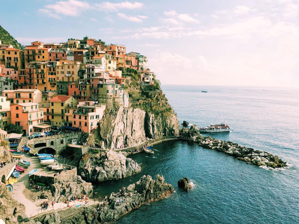 Free Image of Colourful coastal village with cliffs and ocean under a clear sky 