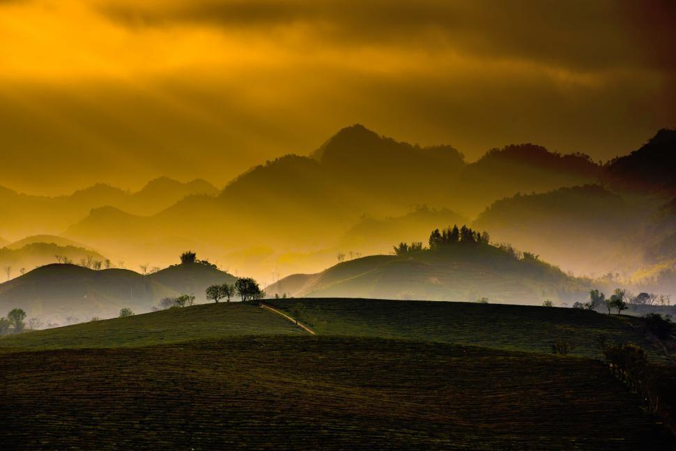 Free Image of Golden sunrise over misty valleys with distant mountain silhouettes. 