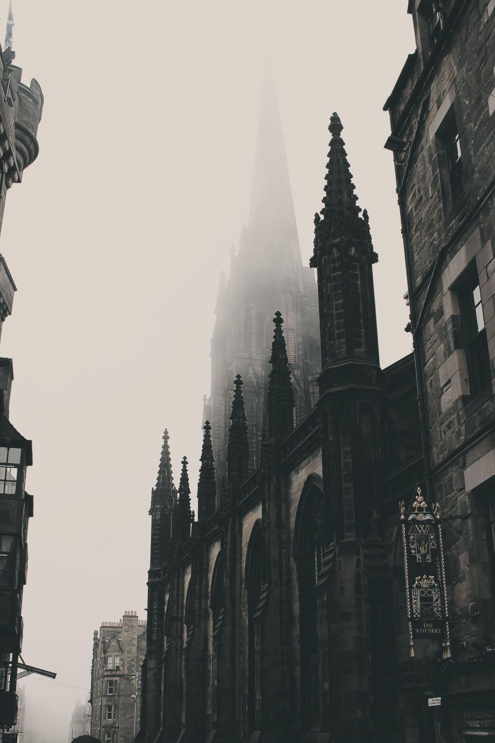 Free Image of Gothic cathedral spires in foggy medieval city street ambiance. 