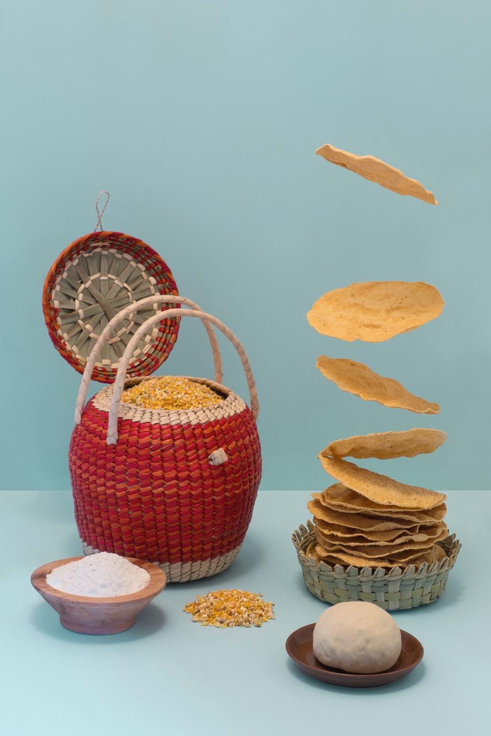 Free Image of Stack of homemade corn tortillas floating over traditional items 