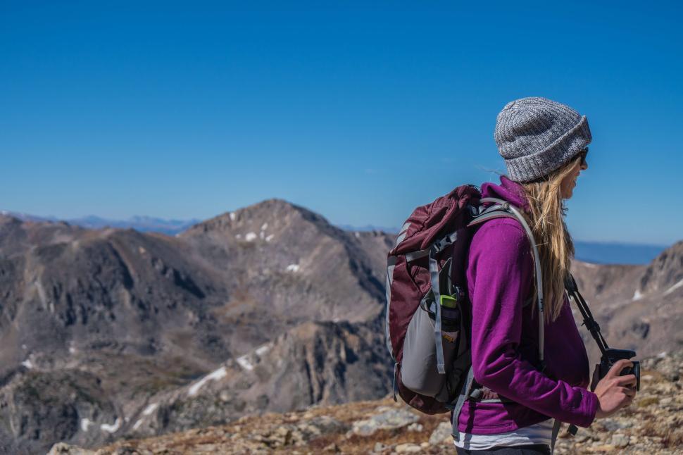Free Image of Woman hiking in mountainous terrain under clear blue sky 
