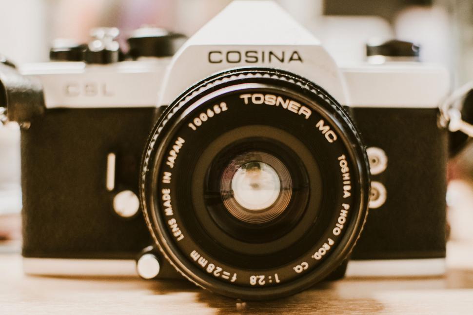 Free Image of Vintage Cosina camera focused on lens placed on a wooden surface 