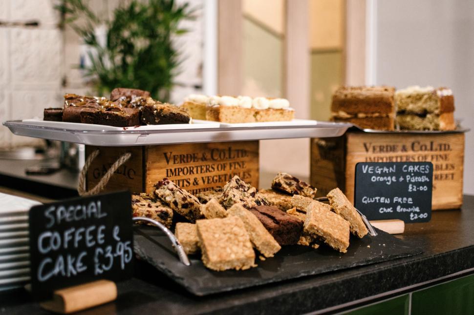 Free Image of Assorted cakes and pastries displayed on a counter with menu prices. 