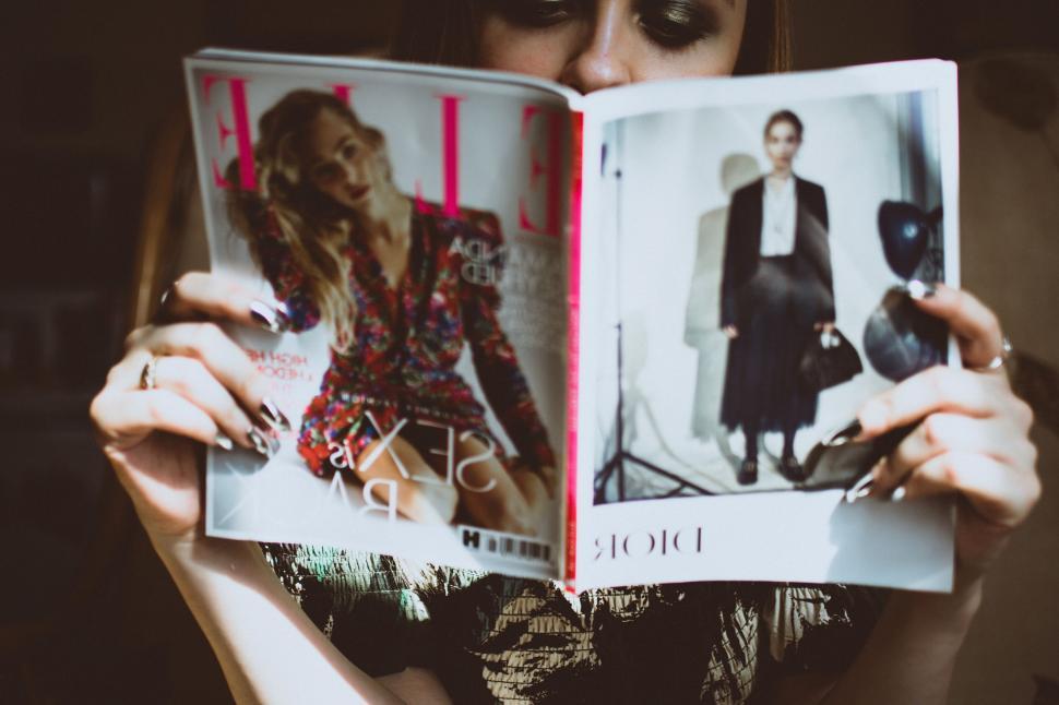 Free Image of Person reading a magazine with fashion content and articles 
