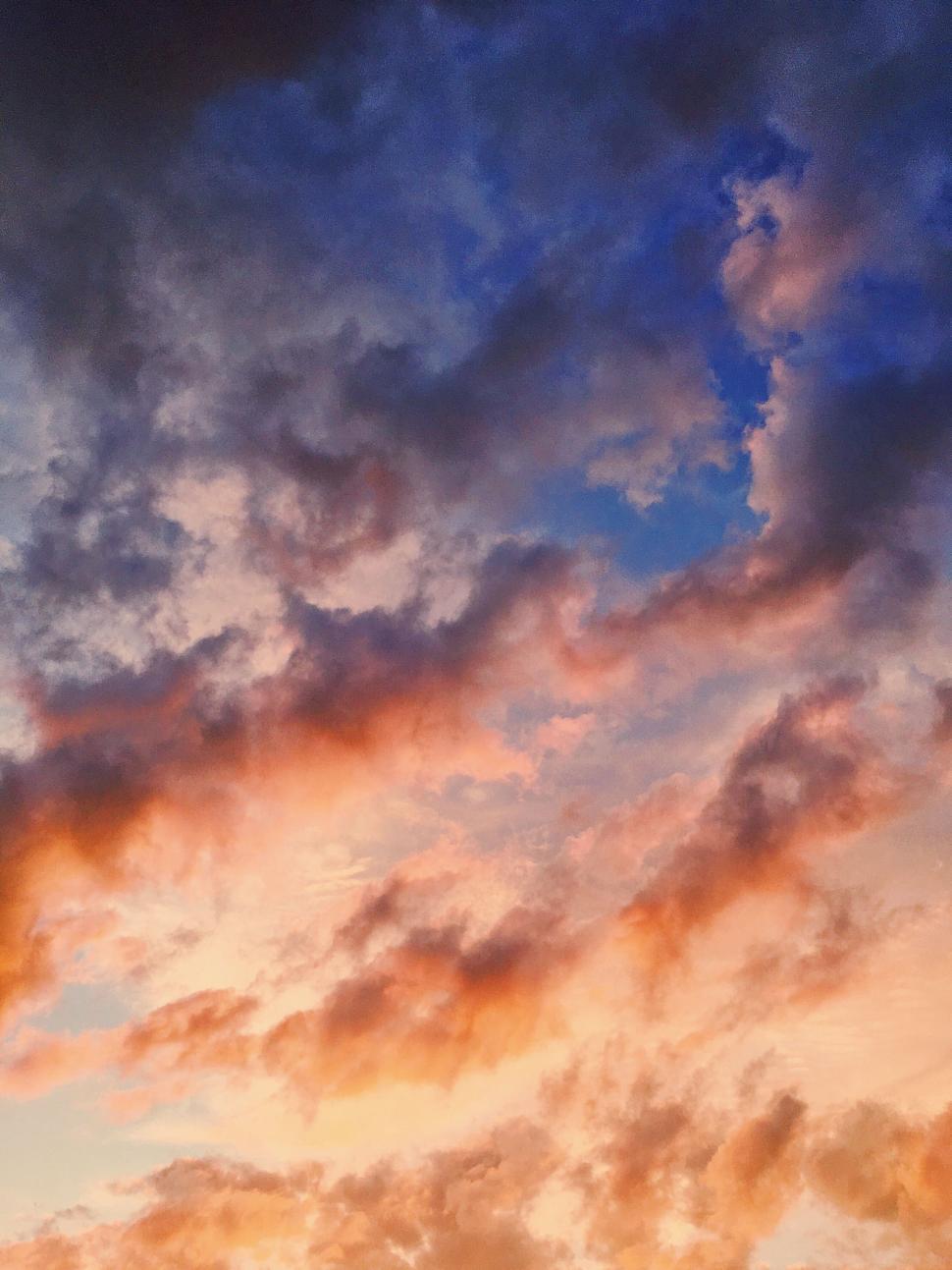Free Image of Vibrant clouds in a colorful sunset sky, radiating warmth. 