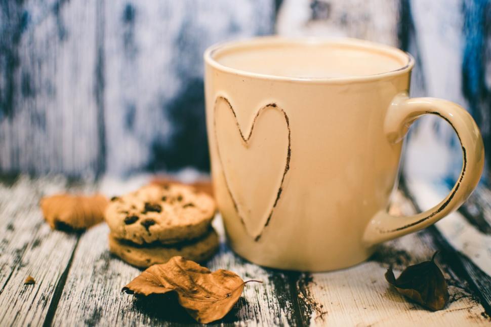 Free Image of Cozy coffee mug on wooden table with cookies and autumn leaves. 
