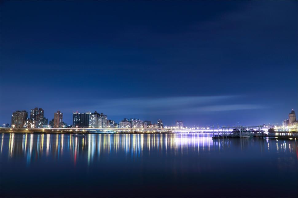 Free Image of A stunning night view of a city skyline reflecting on the calm water. 