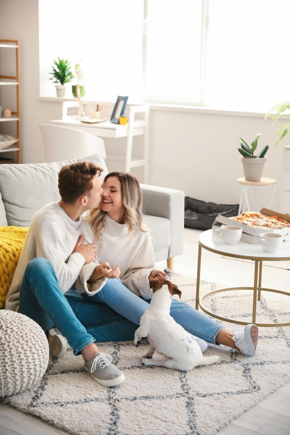 Free Image of Couple sharing an affectionate moment with their dog at home 