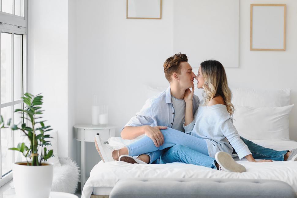 Free Image of Couple embracing and sharing a quiet moment on a white bed 