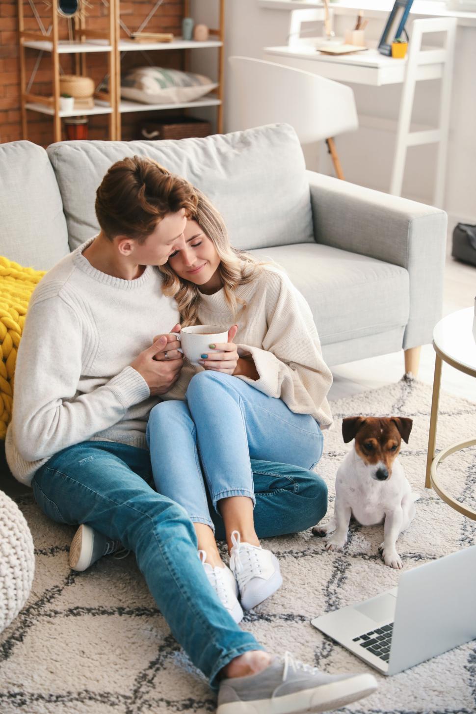 Free Image of A couple enjoying coffee together with their dog nearby 