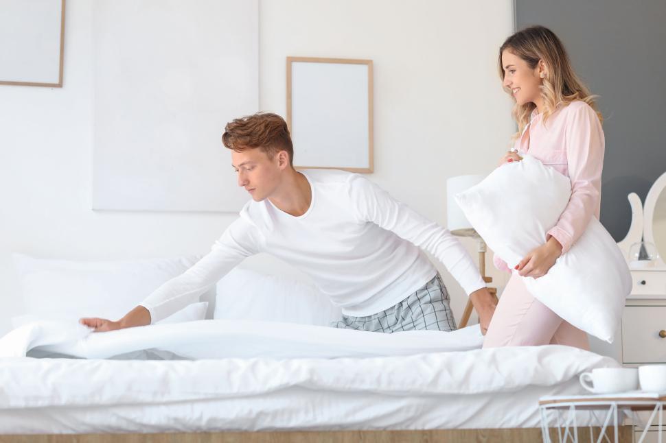 Free Image of A couple making their bed together in the morning 
