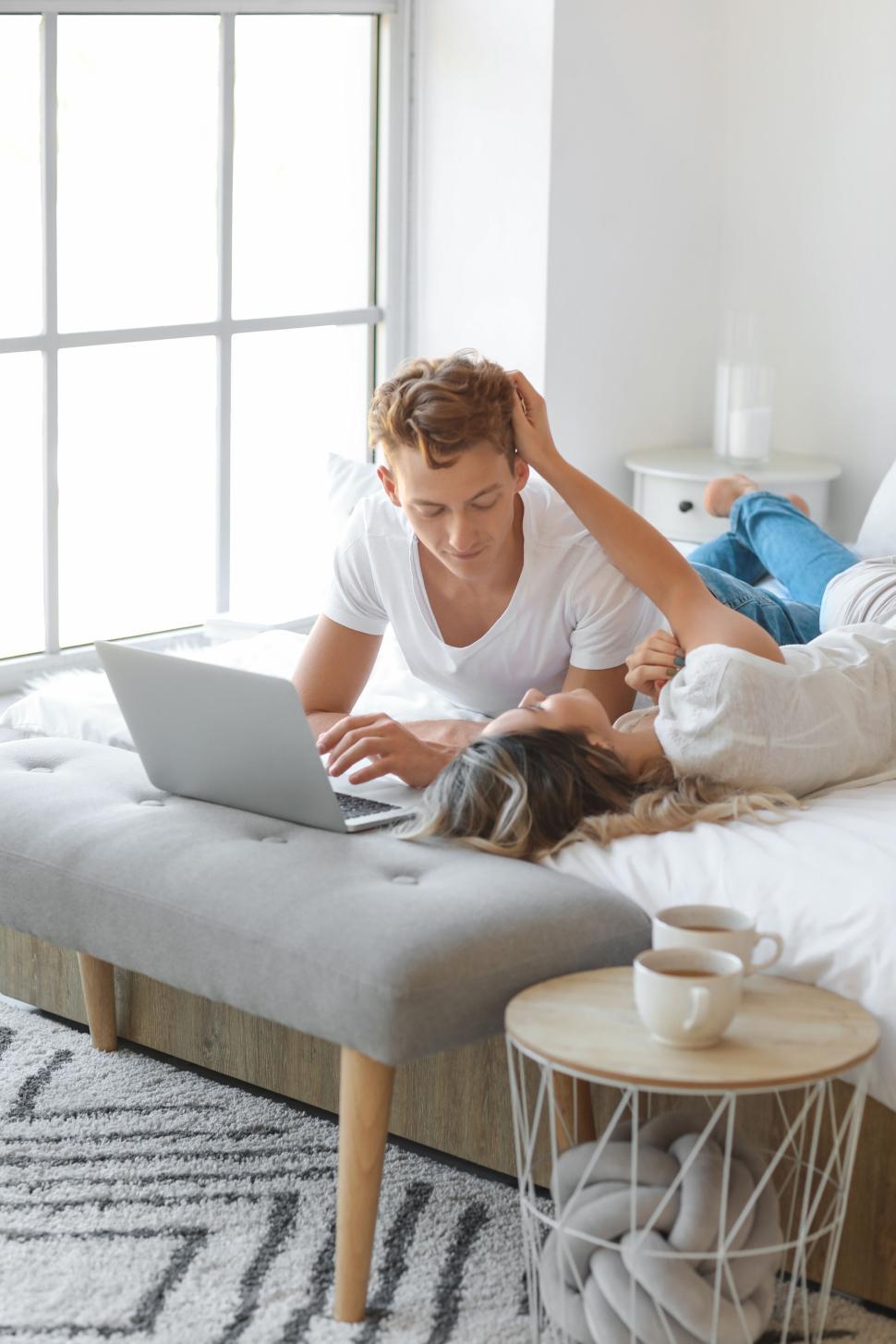 Free Image of Couple enjoying each other s company with laptop on the bed 