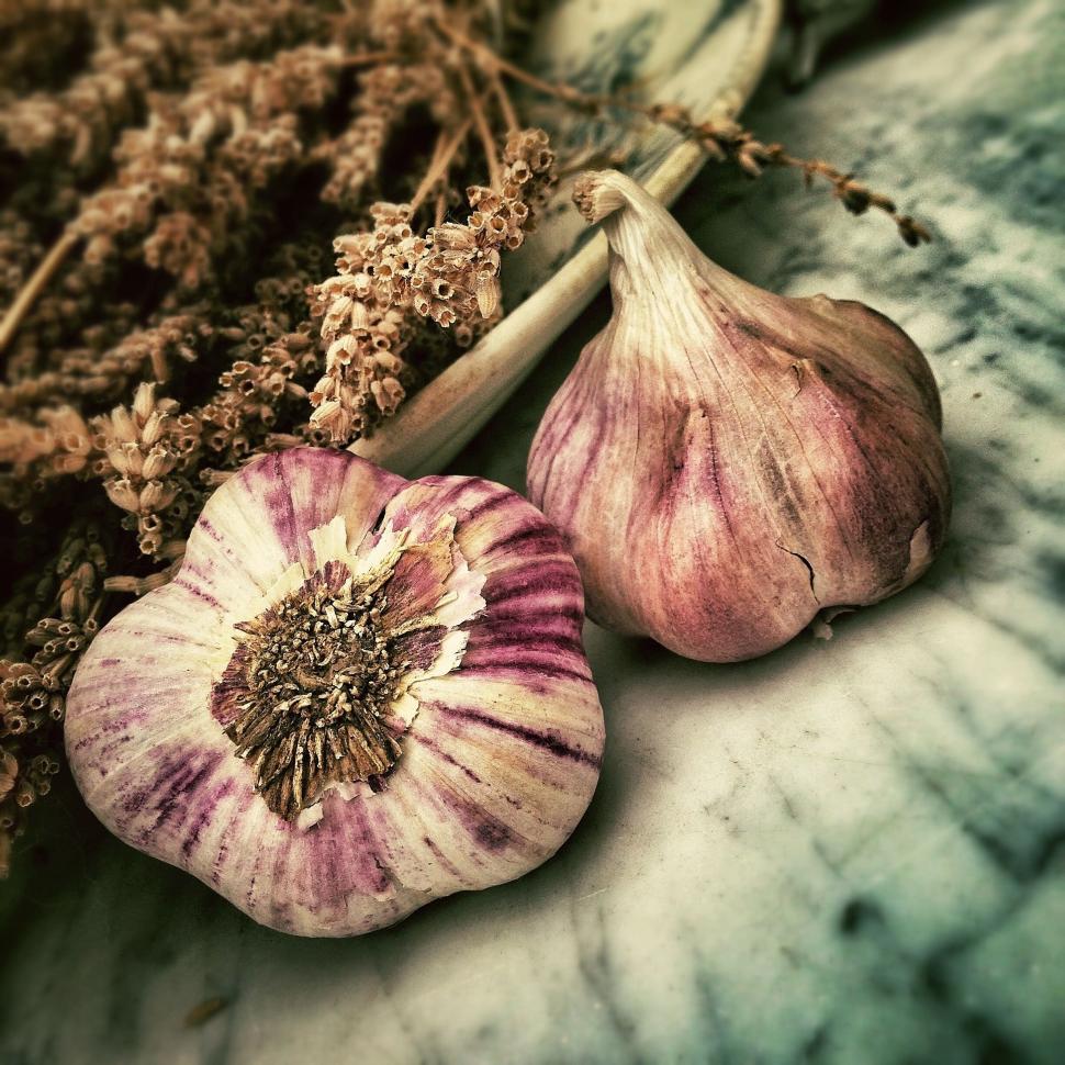 Free Image of Close-up of two garlic bulbs with dry flowers in the background. 