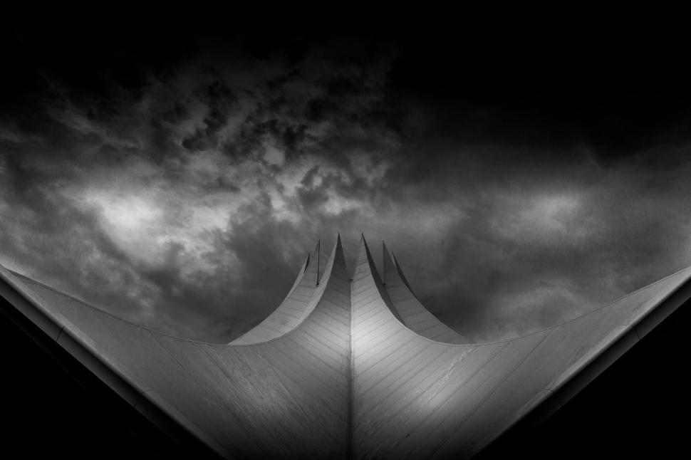 Free Image of Dramatic black and white photo of a building with stormy clouds. 