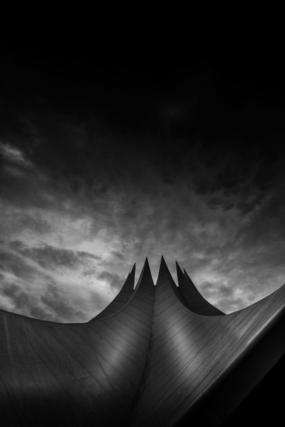 Free Image of Dramatic architectural structure under evening sky in grayscale 