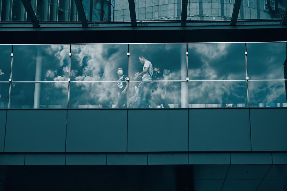 Free Image of People in observation deck reflect in the glass with cloudy sky 